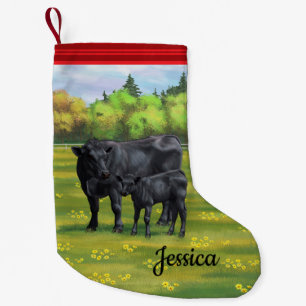 Meia De Natal Pequena Vaca Negra e Vitelo Fresco na Pastagem de Verão