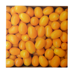 Montão de kumquats alaranjados na caixa de cartã