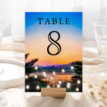 Numeração De Mesa Casamento de Luzes de Corda Solar de Praia Tropica<br><div class="desc">Cartão de número de tabela elegante com tipografia moderna contra um fundo solar romântico.</div>