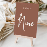 Numeração De Mesa Mesa com script de mão de ferrugem NINE<br><div class="desc">Cartões simples e chic em tons de terra, marrom e branco, fazem uma declaração elegante no seu casamento ou evento. Design apresenta "mesa [number]" em uma combinação de olhares de serif clássica e de caracteres de script manuscritos. Design repete-se de ambos os lados. Cartões numerados individualmente vendidos separadamente; solicite cada...</div>