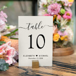 Numeração De Mesa Recepção de casamento Chic Script Cream<br><div class="desc">Sinal de número da tabela de recepção de casamento de creme leve com "mesa" em um roteiro de caligrafia com baloiços, o número da tabela na tipografia sorifônica elegante, seus primeiros nomes unidos por um coração e sua data de recepção. Crie cada número de tabela e adicione ao seu carrinho...</div>