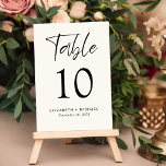 Numeração De Mesa Recepção de casamento de Creme Moderno<br><div class="desc">Sinal moderno do número da tabela de recepções de casamento de creme claro com "Mesa" em um script chic, o número da tabela em tipografia elegante de serifpografia, e seus nomes e data de recepção em uma simples tipografia. Crie cada número de tabela e adicione ao seu carrinho de compro...</div>