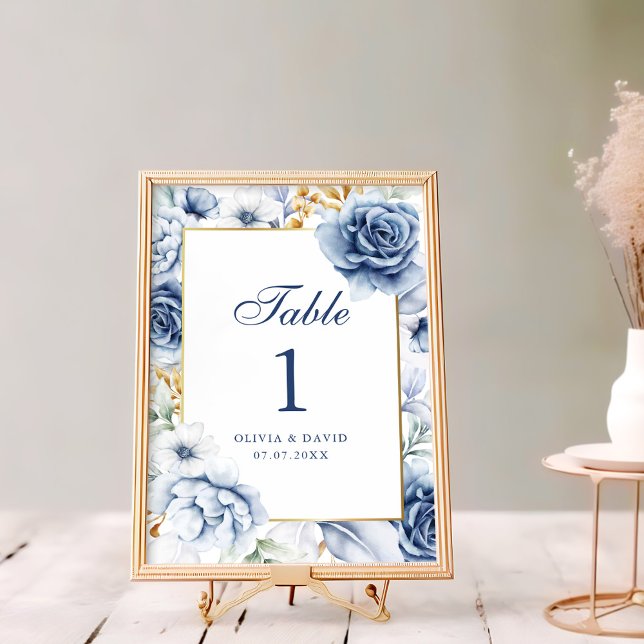 Número da Tabela Floral de Casamento Azul e Dourad (Modern Blue and Gold Floral Wedding Table Number on a rustic white wooden table next to flowers)