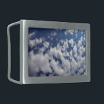 Nuvens Puffy No Céu Azul<br><div class="desc">Um banco de nuvens brancas indefinidas se quebra em pequenas peças sábia através do quadro da fotografia vertical. O cobrir da nuvem é mais denso à esquerda e mais esparso à direita, revelando um céu azul profundo que é escuro perto do topo da foto e mais claro perto do fundo....</div>