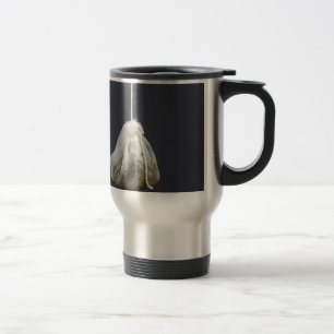 O saco de chá está pendurado em uma xícara