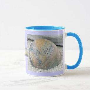 O Seashell no por do sol colore a caneca
