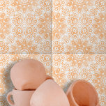 Ornamentado Branco Laranja Claro Simétrico<br><div class="desc">Esse azulejo cerâmico apresenta um intrincado design que é simétrico e sofisticado. O design é caracterizado por ornamentados, formas florais brancas e geométricas que contrastam lindamente com um fundo cor de pêssego e quente. O design é centrado em torno de um elemento em forma de diamante, rodeado por espirais e...</div>