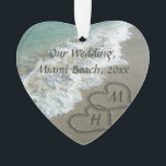 Ornamento Corações de bloqueio da lembrança do casamento de<br><div class="desc">Corações elegantes da areia escritos na praia agradável para simbolizar um casamento do destino ou umas férias tropicais do viagem da lua de mel. Imagem cénico bonita da água clara do oceano de turquesa do aqua, com as ondas brancas que deixam de funcionar na praia tan da areia. Dois corações...</div>
