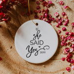 Ornamento De Cerâmica Árvore De Natal Ela Disse Que Sim Envolvida<br><div class="desc">Esta árvore de natal "ela disse sim" é a decoração romântica perfeita da árvore de natal. A design apresenta um anel de diamante,  e as palavras "ela disse sim" com o ano e um pequeno coração arranjado para se parecer com uma árvore de natal.</div>
