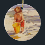 Ornamento De Cerâmica Beach Boy Child em ondas oceânicas<br><div class="desc">Um garotinho mergulhando seu balde nas ondas do oceano Esta é uma bela pintura de um menino pegando água do oceano em seu pequeno balde amarelo. O menino tem cabelos castanhos, troncos de natação vermelha e um balde amarelo brilhante. As ondas do oceano na linha do surf são brancas e...</div>