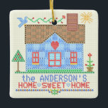 Ornamento De Cerâmica Casa transversal Home doce Home do ponto<br><div class="desc">Este design personalizado da casa de campo é feito para assemelhar-se a um demonstrador do bordado do ponto da cruz do vintage. Mostra uma casa azul feita de "x " s com um pássaro, o sol e abundância dos corações e das flores no mesmo estilo. O fundo é bege com...</div>