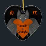 Ornamento De Cerâmica Casais chamam gótica engraçada<br><div class="desc">Um gótico engraçado,  um morcego vampiro bobo,  segurando um grande coração laranja com espaço para dois nomes e no ano atual. Uma forma excelente de um casal mostrar seu amor.</div>