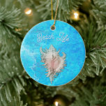Ornamento De Cerâmica Conch Shell "Beach Life"<br><div class="desc">Proclame o seu amor pela "Vida na Praia". Uma concha cor-de-rosa delicadamente tão realista que quase se pode ouvir o oceano. "Beach Life" é exibido com destaque em uma fonte divertida, lembrando os dias sem cuidado passados pela água, e evoca o sentimento de relaxamento em uma praia ensolarada.</div>