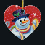 Ornamento De Cerâmica Condecoração de árvore de Natal cardíaca Snowman &<br><div class="desc">A forma cardíaca pica a decoração da árvore de Natal Snowman e tinsel.pinks. Esse bonitão está prestes a decorar sua árvore com uma casca colorida. Veja os outros caracteres nesta mesma série,  Papais noeis e Urso Polar e Rudolph.</div>