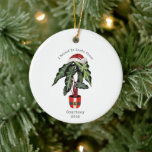 Ornamento De Cerâmica Creio Que No Natal Da Casa Do Pai Natal.<br><div class="desc">Ilustração inspirada por aquarela de uma planta doméstica em papais noeis pote com folhas com chapéu de Santa. O texto diz,  "Eu beleaf no Papai Noel" Personalize com seu nome e ano.</div>