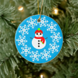Ornamento De Cerâmica Decoração cerâmica Snowman<br><div class="desc">Imagem de um boneco de neve em um floco de neve e fundo azul.</div>
