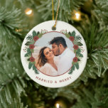 Ornamento De Cerâmica Elegant Floral 2 Photo Married First Christmas<br><div class="desc">Celebrate your first Christmas together and create a treasured keepsake with this beautiful photo ornament! It features hand drawn winter greenery and flowers in rustic colors of brick red and various shades of green over an ivory background. Easy to customize, with photo and text templates on both the back and...</div>