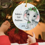 Ornamento De Cerâmica Elephant Baby First Christmas Girl Name<br><div class="desc">Crie uma guarita para o Primeiro Natal de uma menina com este lindo e adorável elefante de menina adorável, adorável, adornado com boughs de pinho e cones de pínus com fundo de floco de neve e personalizado com o PRIMEIRO NATAL DO NAME e ano em um moderno roteiro escrito à...</div>