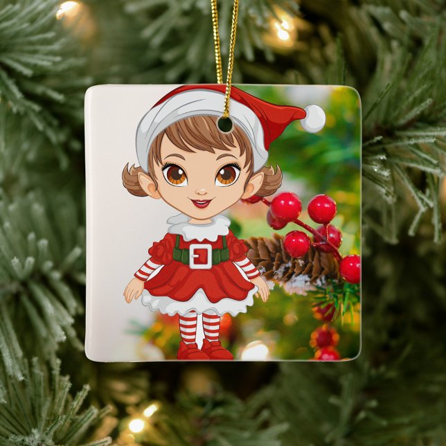 Ornamento De Cerâmica Garotinha Santa Festiva  (Elf is dressed in a festive red and white outfit, stands against a backdrop of a decorated tree.)
