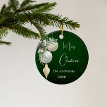 Ornamento De Cerâmica Livro branco de ouro verde<br><div class="desc">Um fundo verde rústico e incolor. Decorado com bolhas brancas e douradas e um pouco de verde e um pinho. Personalize e adicione seu nome,  ano. Texto: Feliz Natal</div>