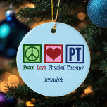Ornamento De Cerâmica Paz Amor Terapia Física Feliz Natal Personalizado<br><div class="desc">Este presente de Enfeites de natal fisioterapeuta apresenta um bonito sinal de paz,  coração e as letras PT. Uma bela e personalizada terapia física presente. Paz Amor Terapia Física.</div>