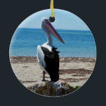 Ornamento De Cerâmica Pelican On Beach Rock,<br><div class="desc">Apresentado em uma rocha de praia perto do oceano é um pelicano faminto e bonito esperando por mariscos-pesadelos.</div>
