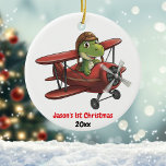 Ornamento De Cerâmica Personalizado, dinossauro de avião bonito, Natal d<br><div class="desc">Design apresenta um dinossauro fofo com um capacete piloto voando um avião vermelho. Na parte inferior da imagem está o texto '[Name] 1rua Natal' e ano. Personalize este ornamento com seus detalhes específicos. Isso seria perfeito para aquele pequeno aviador! Copyright Soar em Style Design LLC.</div>