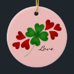 Ornamento De Cerâmica Shamrock e corações<br><div class="desc">Um belo design com um trevo de quatro folhas com sorte,  com corações vermelhos,  e a palavra "Amor" num fundo cor-de-rosa neste ornamento em forma de círculo bonito.</div>
