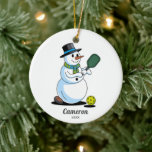 Ornamento De Cerâmica Snowman Engraçado Pickleball, Adicionar Fotografia<br><div class="desc">Um Enfeites de natal super divertido de picleball com um boneco de neve jogando picleball. Adicione seu texto personalizado à foto do jogador de seleção e da frente ao lado de trás. Faz o presente perfeito para o seu parceiro de piquenique, papais noeis secretos, treinador, coordenador de equipe ou qualquer...</div>