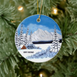 Ornamento De Cerâmica Snowy Winter Round<br><div class="desc">Um ornamento de férias com uma bela cena de inverno,  incluindo montanhas cobertas de neve,  evergreens e cabana rustica. As imagens e o texto podem ser personalizados,  substituídos ou excluídos. Arte original por W.B.</div>