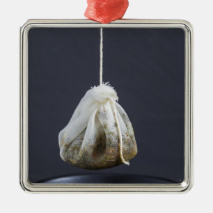 Ornamento De Metal O saco de chá está pendurado numa xícara