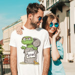 Oscar, o Grouch Scram<br><div class="desc">Mostre seu amor por Oscar,  o Grupo com este "Scram!" T-Shirt com a personagem da rua Sesame. A design destaca o charme grumante de Oscar com texto ousado e sua famosa expressão,  fazer-o uma escolha divertida e divertida para fãs de todas as idades.</div>