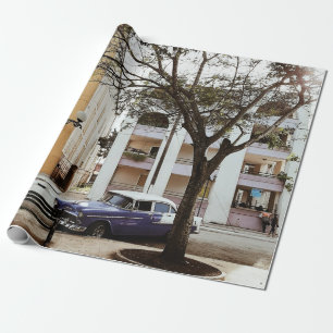 PAPEL DE PRESENTE SEDAN AZUL ESTACIONADO PERTO DO EDIFÍCIO BRANCO