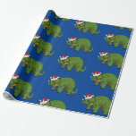 Papel De Presente Tricerátops de Natal Papel de Envolvimento Dinossa<br><div class="desc">Um desenho de um dinossauro triceratops vestindo um chapéu de Papai Noel e um cachecol vermelho e amarelo ao redor do pescoço.</div>