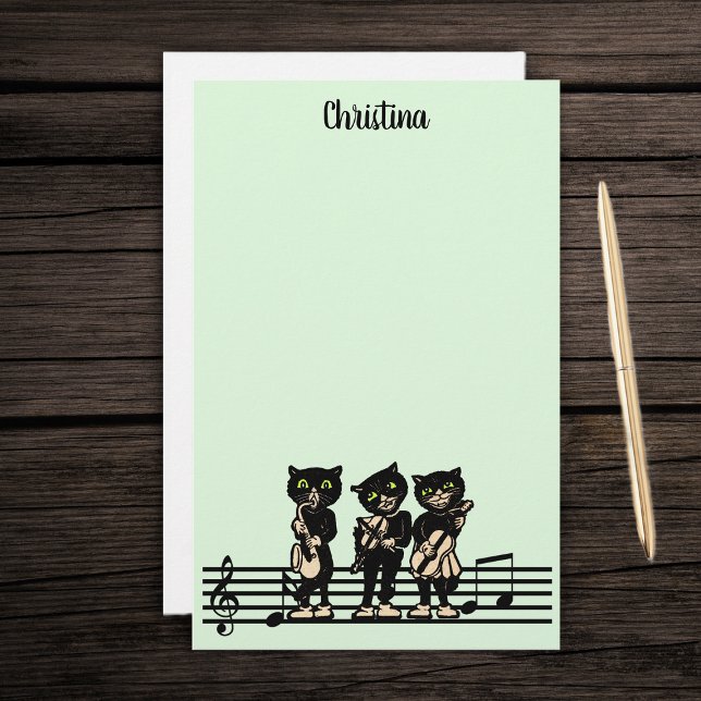 Papelaria Três Músicos de Gato Negro Instrumentos de Música  (Three black cat musicians playing instruments on bar of music notes on green stationery paper pad.)