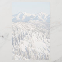 Uma vista cénico de montanhas nevado e de árvores