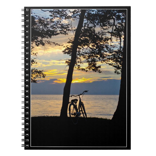 Por do sol sobre o lago com caderno da bicicleta (Frente)