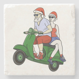 Porta-copo De Pedra Papais noeis e Sra. Claus andando em patinete