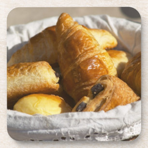 Porta-copo Uma cesta de café da manhã com croissants e