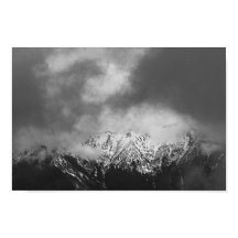 Montanhas negras e brancas em nuvens