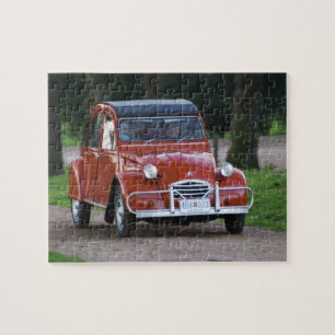 Quebra-cabeça Um velho Citroen 2CV vermelho com uma mulher sorri