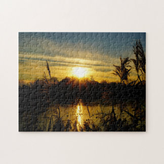 Quebra-cabeça Zonsondergang bij een meertje met rietpluimen.