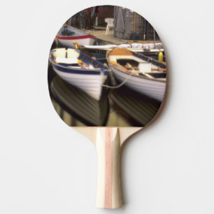 Raquete De Ping Pong Névoa cerca quatro barcos atracados.