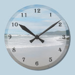 Relógio de Parede Praia<br><div class="desc">Procurando um relógio de parede temático na praia? Este design de relógio pode ser exatamente o que você está procurando enquanto mostra uma cena de praia com as ondas entrando em uma praia arenosa e as montanhas à distância. Uma maneira adorável de adicionar um tema de praia à sua casa....</div>