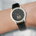 Relógio Monograma Dourado preto-e-legante<br><div class="desc">Monograma personalizado, relógio preto e branco com números brancos simples. Este elegante relógio minimalista combina o estilo clássico com um toque pessoal, apresentando uma inicial dourada (nota: o ouro é de cor plana sem nenhum cintilador) numa face preta, realçada por simples números brancos para fácil leitura. O design também inclui...</div>