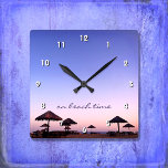 Relógio Quadrado Em Beach Time California Purple Pink Sunset Foto<br><div class="desc">"Na hora da praia." Um pôr do sol roxo, azul e rosa, numa praia do sul da Califórnia com aquele palapas chocados consome relaxamento e reflexão. Relaxe, cheire o ar do oceano, e lembre-se das memórias do verão sempre que você verifica o tempo neste relógio de chic, na moda, fotografia...</div>