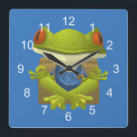 Relógio Quadrado Funny Meditating Frog<br><div class="desc">A funny meditating frog cartoon design. You can change the blue background to the color of your choice by using the "customize it" option.</div>