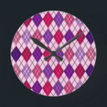 Relógio Redondo Art Deco Argyle<br><div class="desc">Este relógio de parede tem um design de deco de arte de formas de diamante feitas de ângulos sobrepostos em linhas pretas coloridas em tons roxos e cor-de-rosa com linhas pretas diagonais fazeres a design parece argyle</div>