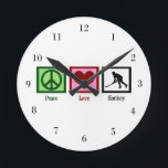 Relógio Redondo Hóquei em Paz<br><div class="desc">Um sinal de paz, coração, e um jogador de hóquei jogando hóquei no campo.</div>