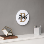 Relógio Redondo Nome do Monograma Elegante Moderno Script Dourado<br><div class="desc">O Relógio de Script Dourado Preto do Nome Elegante Moderno é um na moda e um relógio personalizado perfeito para qualquer configuração de casa ou escritório. Este relógio apresenta uma face preta elegante com um guião de ouro elegante, permitindo-lhe personalizá-lo com o seu monograma e nome. O design moderno e...</div>